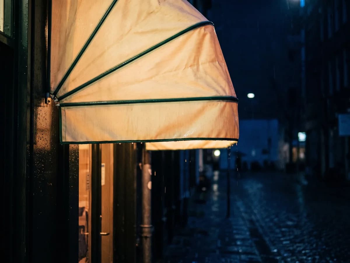 Beleuchtete Markise über einem Ladeneingang bei Nacht